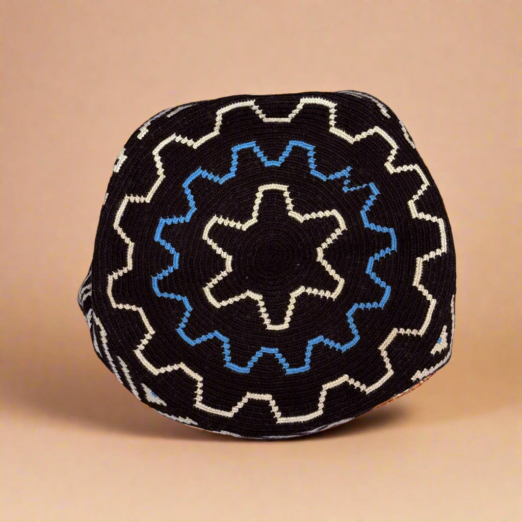 Black fabric with blue and white geometric pattern on a light gray background